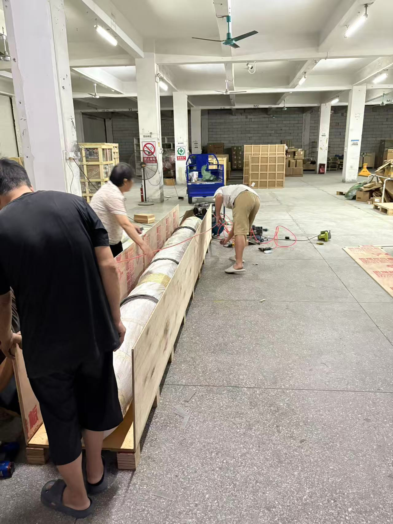 Workers packing the five-metre carpet into its export wooden case